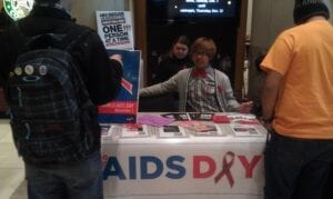 Member of Lambda Student Union heading out information on HIV/AIDS to interested to students.