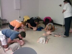 Students engaging in CPR training with the Clinic Vols